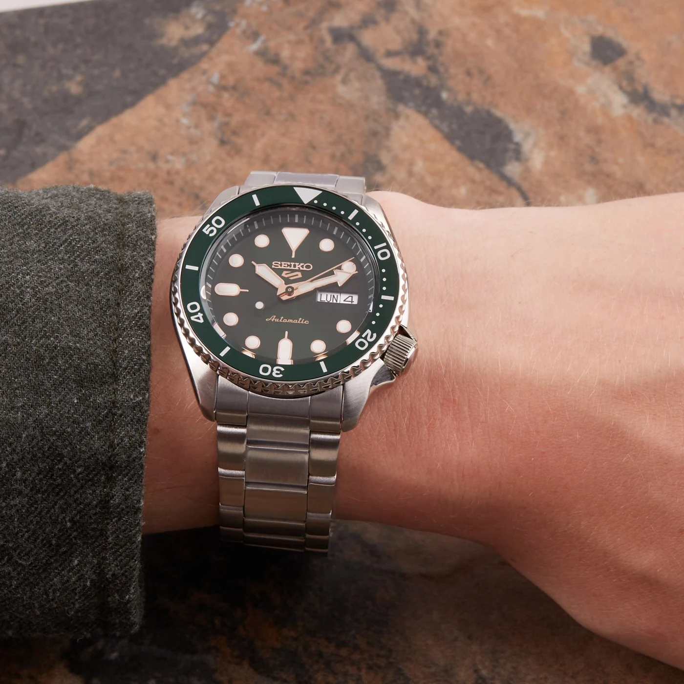 Montre Seiko 5 Sports SRPD63K1 portée au poignet, cadran vert et bracelet acier