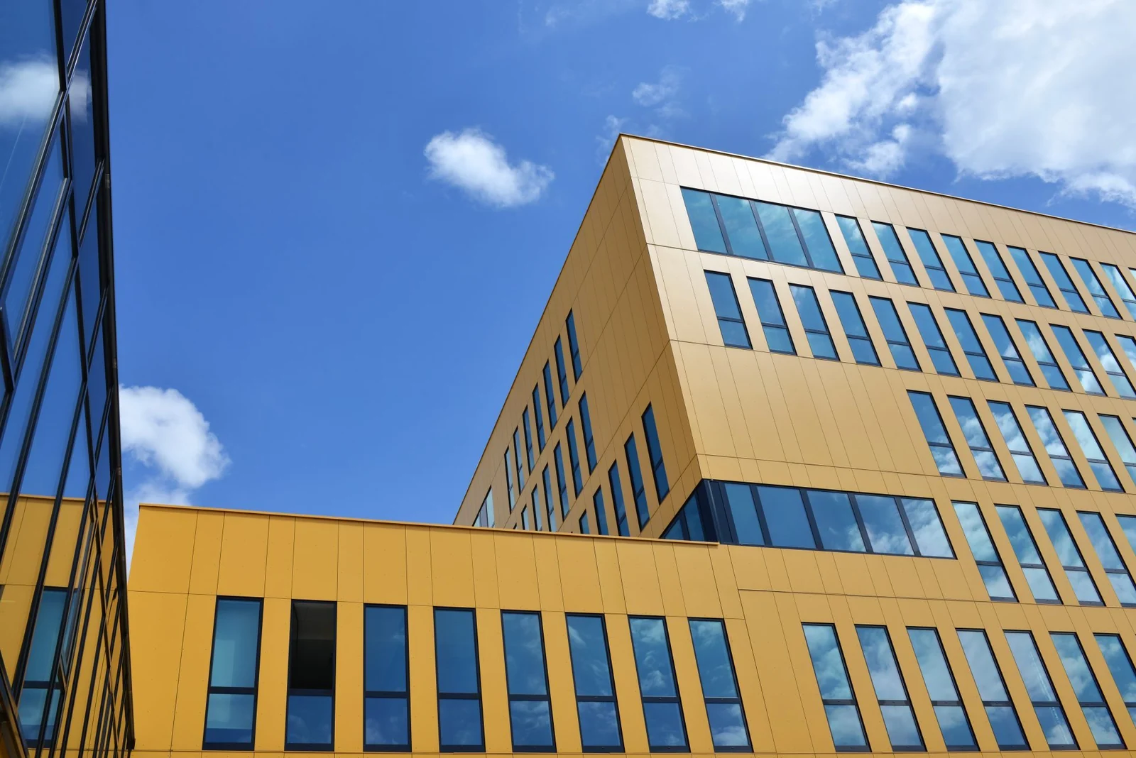 Architecture de La Jonxion, façade jaune et ciel bleu