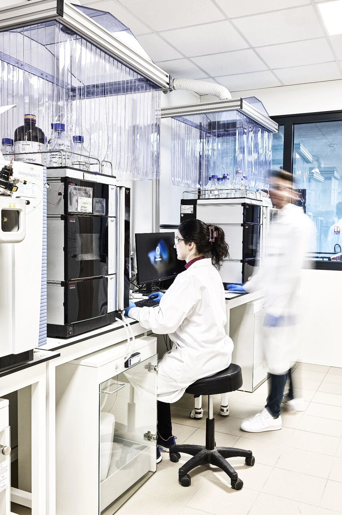 Une technicienne du laboratoire Filab travaille devant des instruments d’analyse et son poste informatique.